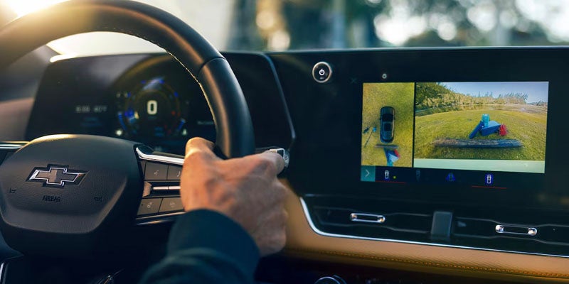 Close up view of the 2025 Chevrolet Equinox steering wheel and parking assistance on the touch screen