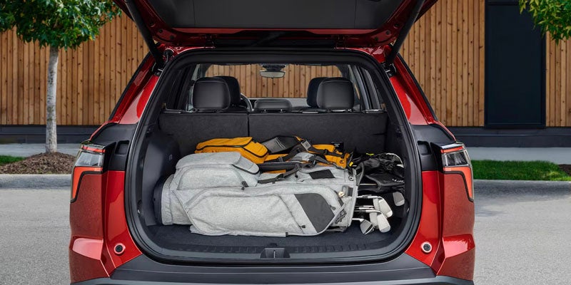 Rear view of 2025 Chevrolet Equinox with two golf bags in the open trunk