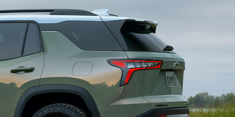2025 Chevrolet Equinox rear view on a beach with close up on back left headlight