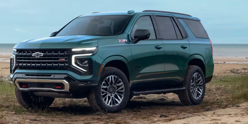 Front side view of the 2025 Chevrolet Suburban parked in front of a beach
