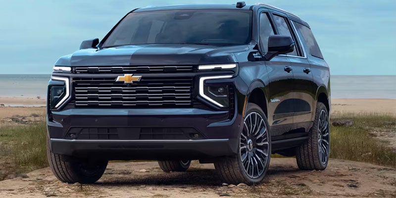 Front view of the 2025 Chevrolet Suburban parked in front of a beach