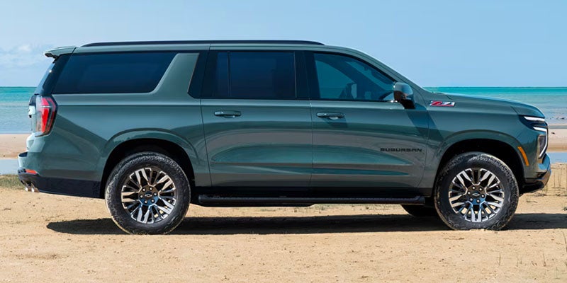 Side view of the 2025 Chevrolet Suburban parked in front of a beach