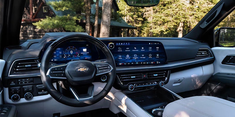 Close up view of the dashboard of the 2025 Chevrolet Suburban, including the steering wheel, AC vents, temperature controls and touch screen