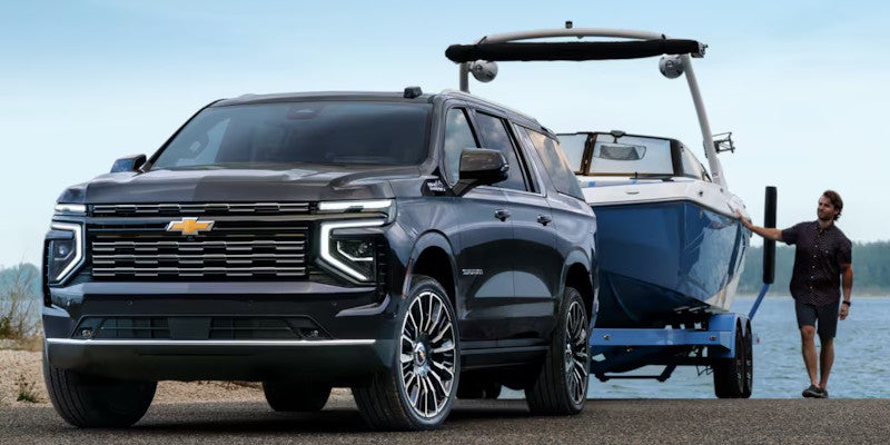 Front view of the 2025 Chevrolet Suburban towing a boat and backing it up into the water