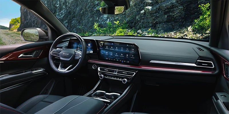 Interior view from the front passenger seat of the 2025 Chevrolet Traverse. Visible center console, steering wheel, dashboard and touch screen.