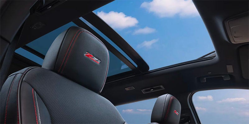 Close up view of the front passenger seat and the open sunroof above