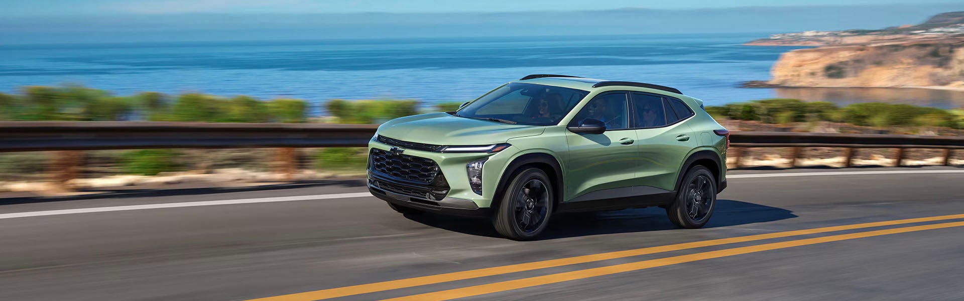 Wide shot of 2025 Chevy Trax on a highway near water