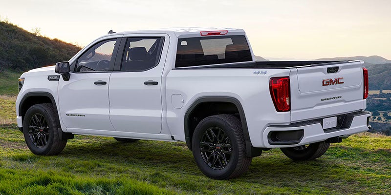 Side view of GMC Sierra 1500 on a grassy hill