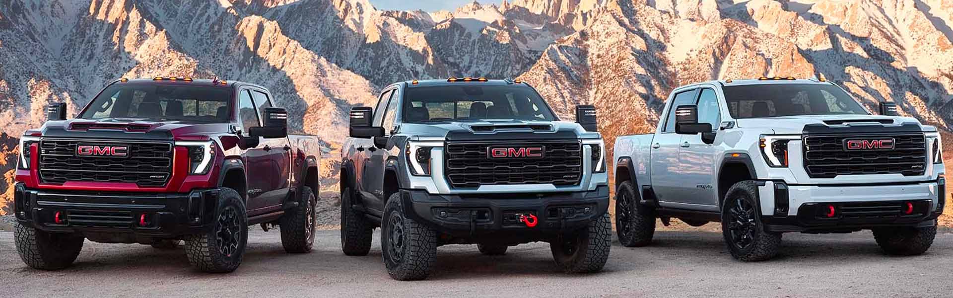 Front view of 3 2025 GMC Sierra 2500s on a mountain top