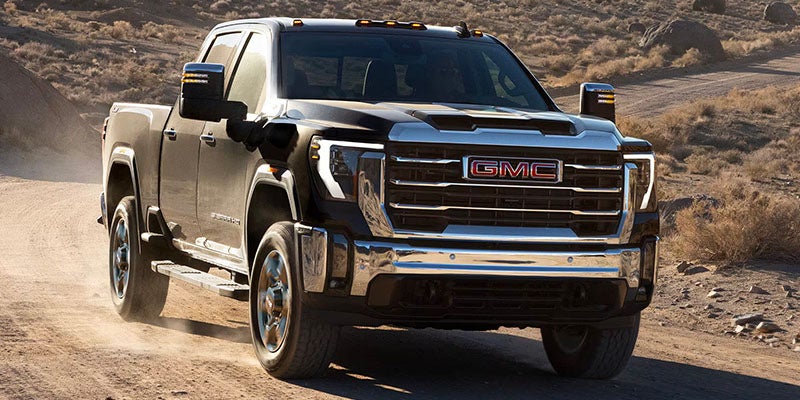 Front view of the 2025 GMC Sierra 2500 driving on a mountain