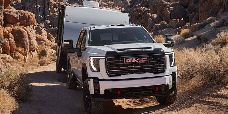 2025 GMC Sierra 2500 pulling a trailer up a mountain