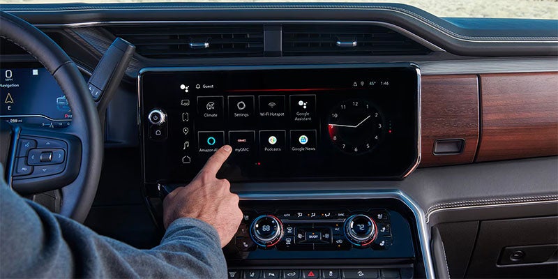 Close up of driver interacting with 2025 GMC Sierra 2500 front dashboard touch screen